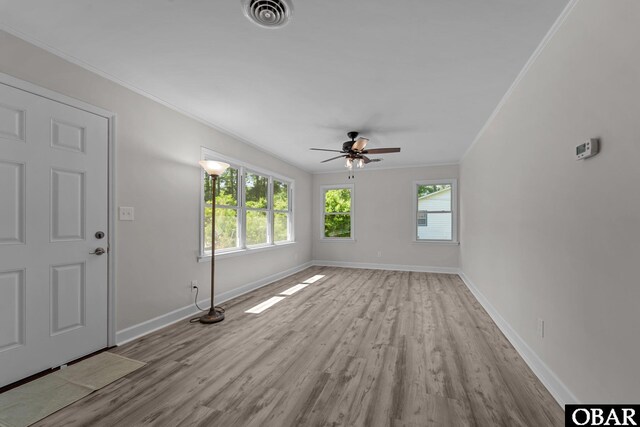 unfurnished living room with wood finished floors, baseboards, ornamental molding, and ceiling fan