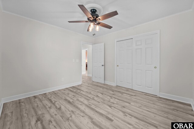 unfurnished bedroom with light wood-type flooring, crown molding, baseboards, a closet, and a ceiling fan