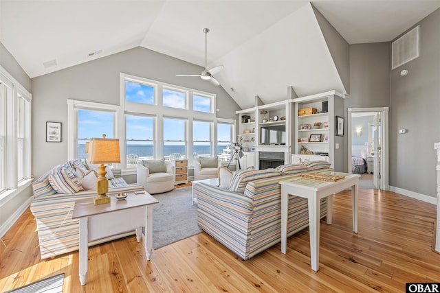 5006 S Links Dr Lot 6, Nags Head, NC 27959 - living area with visible vents, ceiling fan, light wood-style floors, a fireplace, and high vaulted ceiling