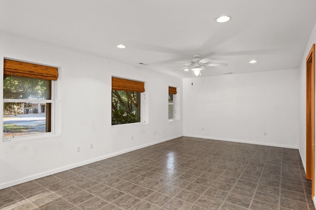 empty room featuring dark floors, baseboards, a ceiling fan, and recessed lighting