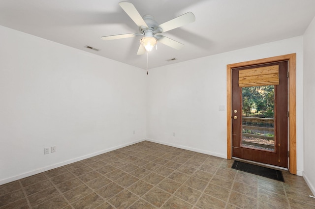 spare room with baseboards, visible vents, and a ceiling fan