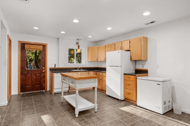 kitchen featuring recessed lighting, white appliances, a sink, and light brown cabinetry