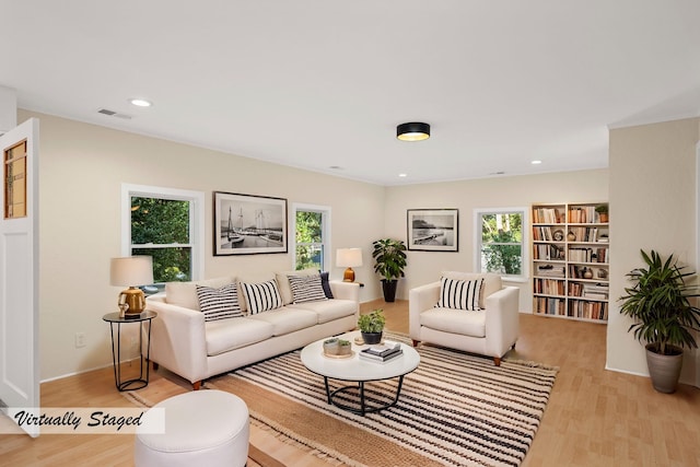 living room with a healthy amount of sunlight, visible vents, and light wood-style flooring