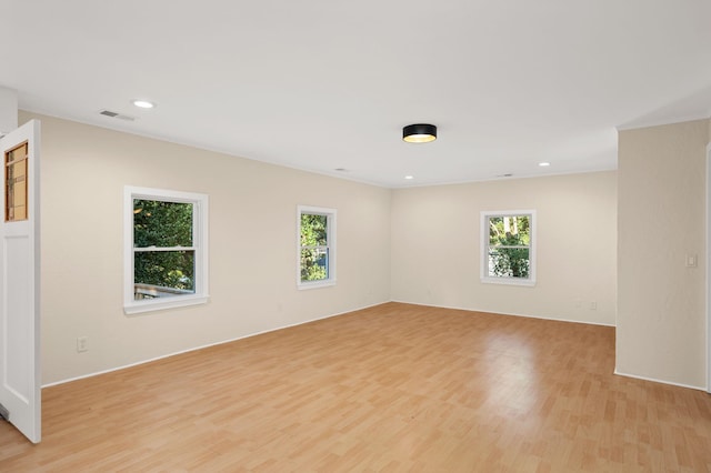 unfurnished room featuring light wood finished floors, plenty of natural light, visible vents, and recessed lighting