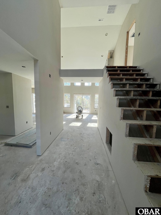 interior space featuring a towering ceiling and visible vents