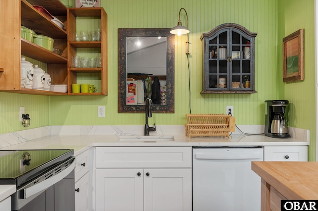 kitchen featuring white dishwasher, a sink, white cabinets, wooden counters, and open shelves