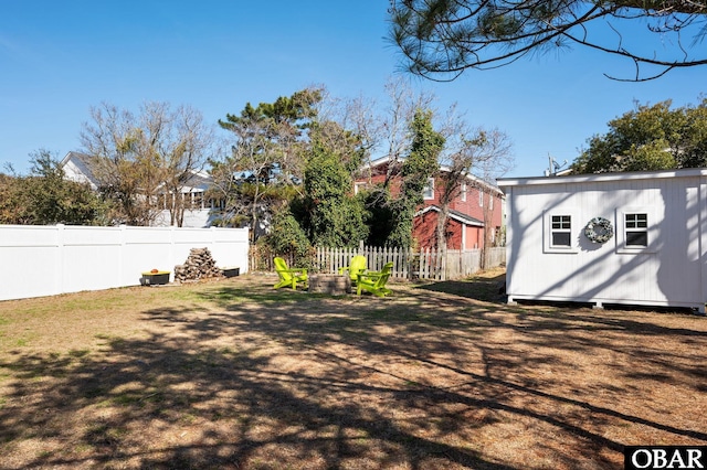 view of yard featuring a fenced backyard, an outdoor structure, and a storage unit