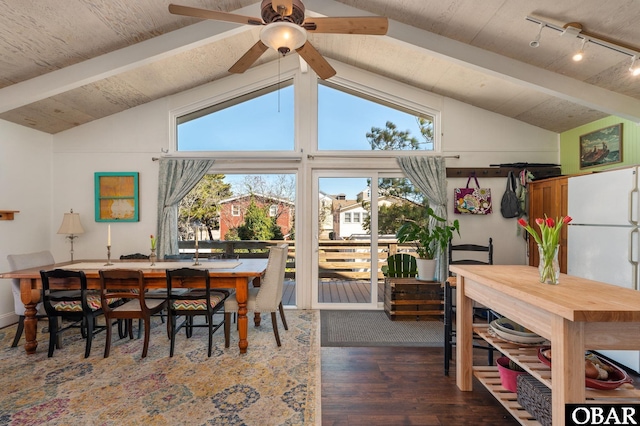 dining room featuring a ceiling fan, dark wood-style flooring, and vaulted ceiling with beams