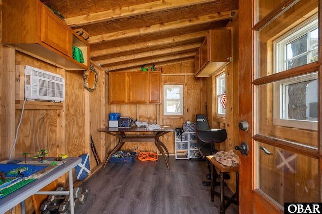 interior space featuring lofted ceiling, a wall mounted AC, dark wood finished floors, and wooden walls