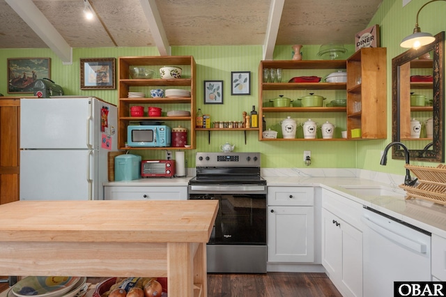 kitchen featuring white appliances, wood counters, beamed ceiling, white cabinetry, and a sink