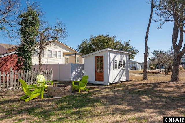 view of shed featuring fence and a fire pit