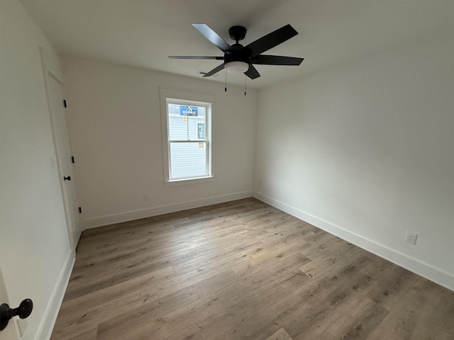 unfurnished room with light wood-style floors, ceiling fan, and baseboards