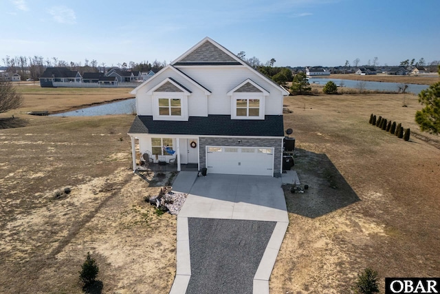 traditional home featuring a garage, a water view, and concrete driveway