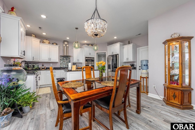 dining room with visible vents, baseboards, light wood-type flooring, recessed lighting, and an inviting chandelier