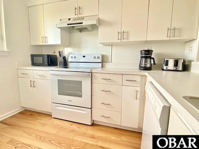 kitchen featuring light wood-type flooring, white appliances, under cabinet range hood, and light countertops