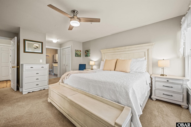 bedroom with light carpet, ceiling fan, connected bathroom, and a closet