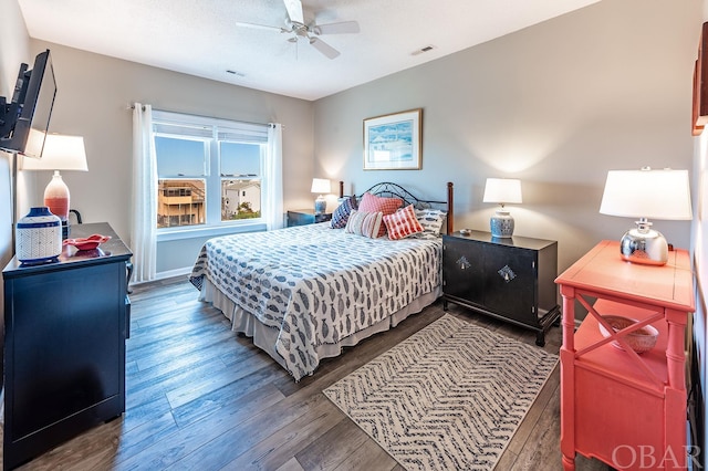 bedroom featuring ceiling fan, visible vents, dark wood finished floors, and a textured ceiling