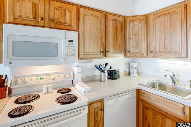 kitchen with a sink, white appliances, and light countertops