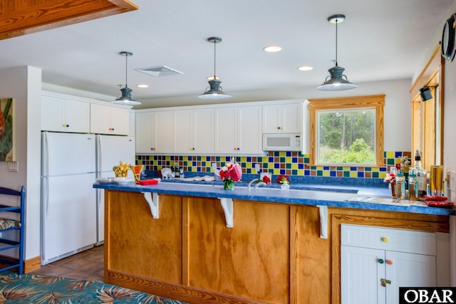 1700 Paget Rd Unit C 3, Kill Devil Hills, NC 27948 - kitchen with white appliances, backsplash, white cabinetry, decorative light fixtures, and recessed lighting