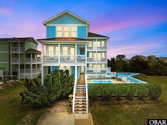 24205 Caribbean Ct Lot 8, Rodanthe, NC 27968 - back of house featuring a balcony, stairway, a standing seam roof, a community pool, and metal roof