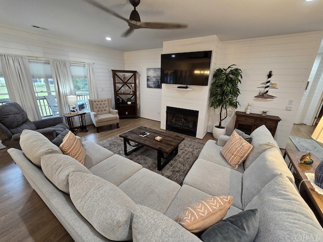 living area with recessed lighting, dark wood-type flooring, a fireplace, visible vents, and a ceiling fan