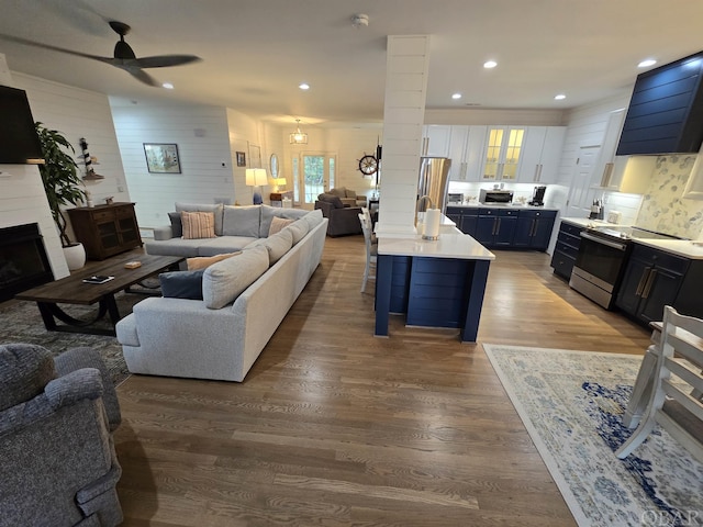 living room with a fireplace, decorative columns, recessed lighting, a ceiling fan, and wood finished floors