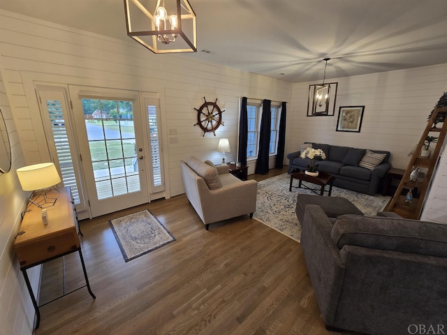 living room with dark wood finished floors, visible vents, and an inviting chandelier