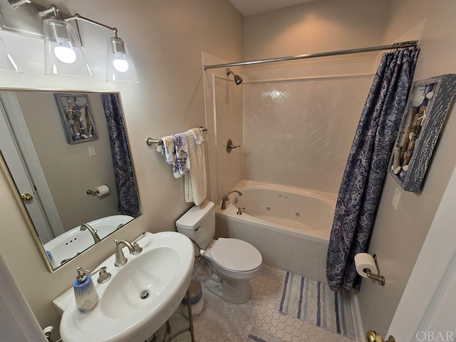 bathroom with a sink, tiled shower / bath, toilet, and tile patterned floors