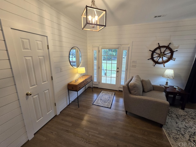 doorway to outside featuring a notable chandelier, visible vents, and dark wood-style flooring