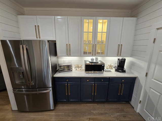 kitchen with appliances with stainless steel finishes, light countertops, white cabinets, and blue cabinetry