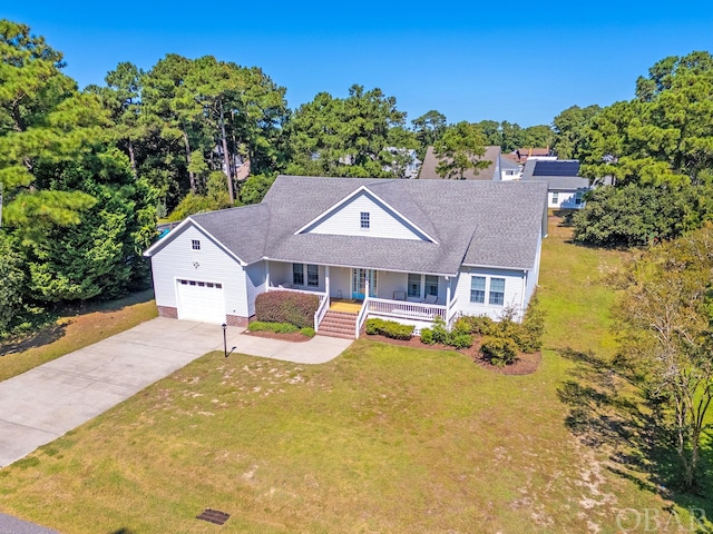 view of front of property featuring covered porch, an attached garage, driveway, and a front lawn