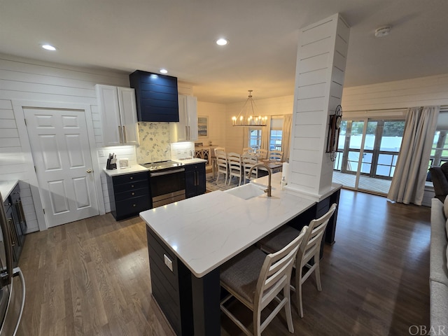 kitchen with dark wood-type flooring, a sink, white cabinets, hanging light fixtures, and stainless steel electric stove