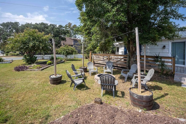 view of yard featuring an outdoor fire pit and fence