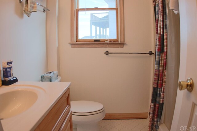 bathroom with curtained shower, vanity, toilet, and tile patterned floors