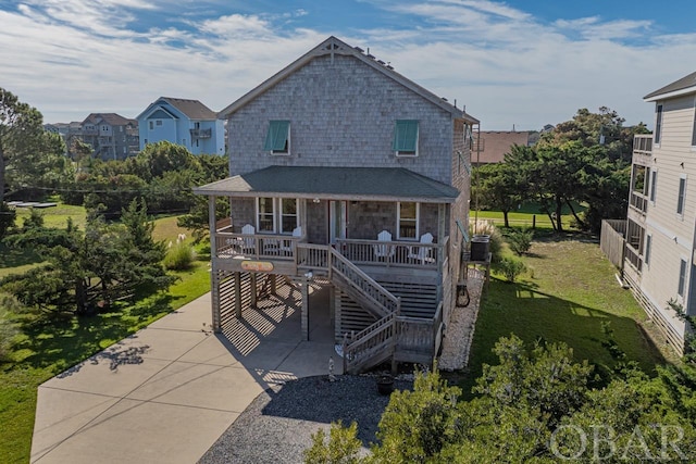 view of front of house with covered porch, stairway, a front yard, and central air condition unit