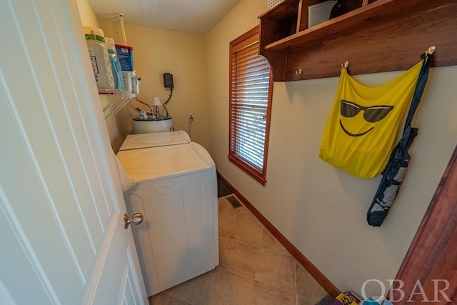 laundry area with laundry area, visible vents, baseboards, washing machine and dryer, and light tile patterned flooring