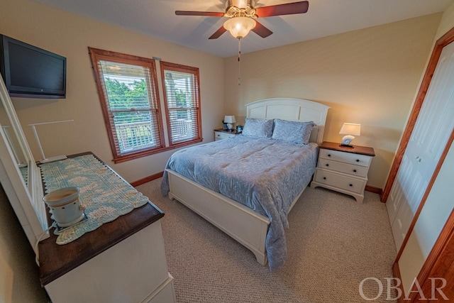 bedroom with light carpet, baseboards, and a ceiling fan