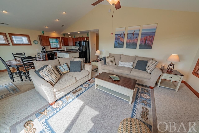 living area featuring light colored carpet, visible vents, a ceiling fan, high vaulted ceiling, and baseboards