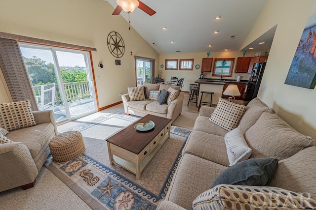 living area with recessed lighting, baseboards, high vaulted ceiling, and light colored carpet