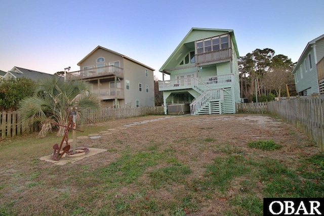 back of house with a fenced backyard and stairway