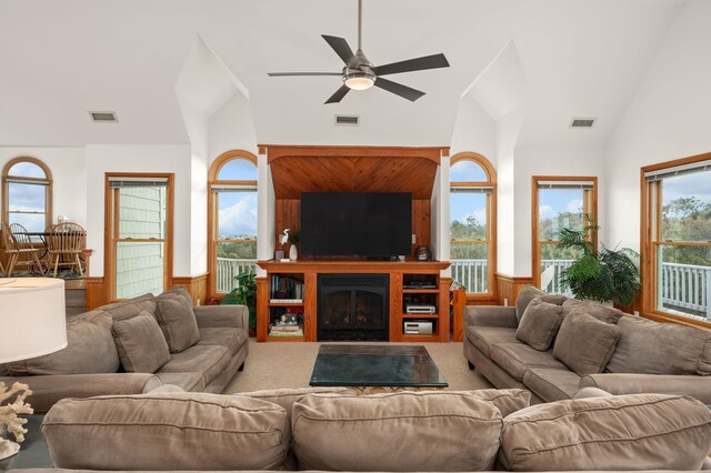 carpeted living area with visible vents, a glass covered fireplace, and wainscoting