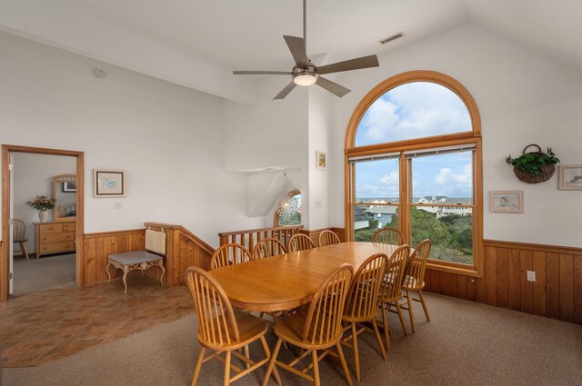 dining space with carpet floors, a wainscoted wall, wood walls, and visible vents