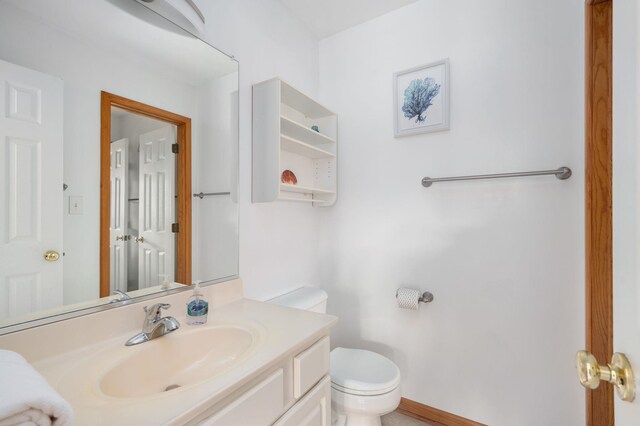 bathroom featuring vanity, toilet, and baseboards