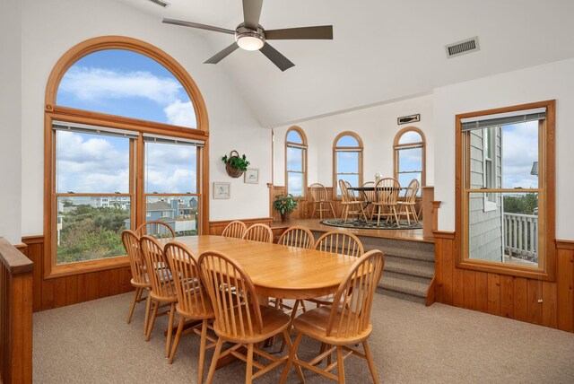 dining area featuring light carpet, visible vents, and wainscoting