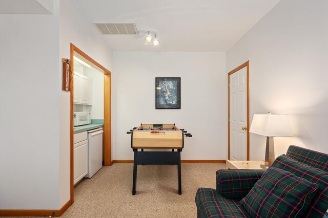 interior space featuring light colored carpet, visible vents, and baseboards