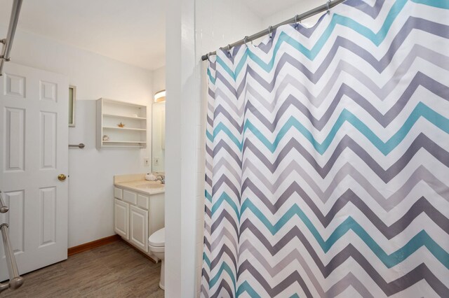 bathroom featuring a shower with curtain, vanity, toilet, and wood finished floors