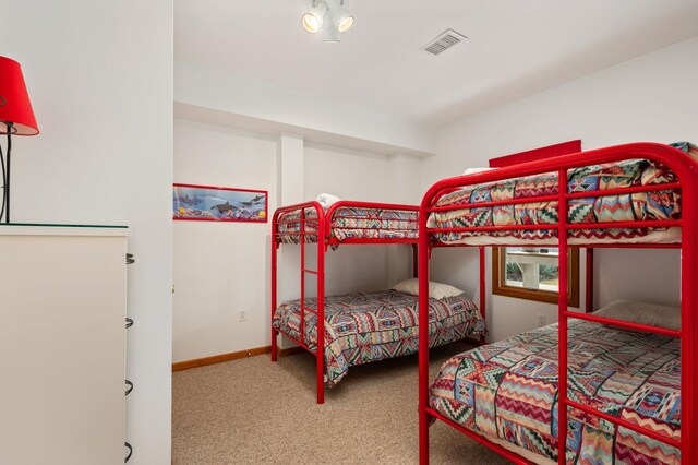 carpeted bedroom featuring baseboards and visible vents