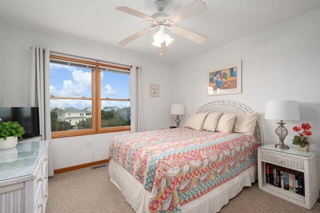 bedroom with baseboards, visible vents, ceiling fan, and light colored carpet