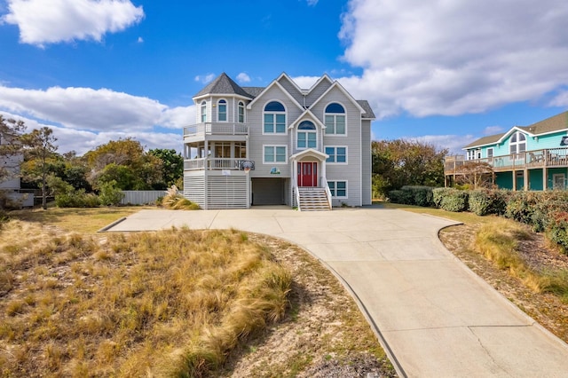 view of front of home with concrete driveway and a balcony