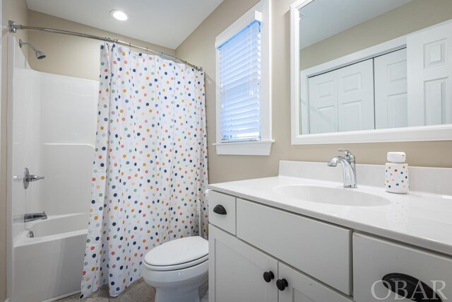 full bath featuring toilet, a closet, vanity, and shower / tub combo with curtain